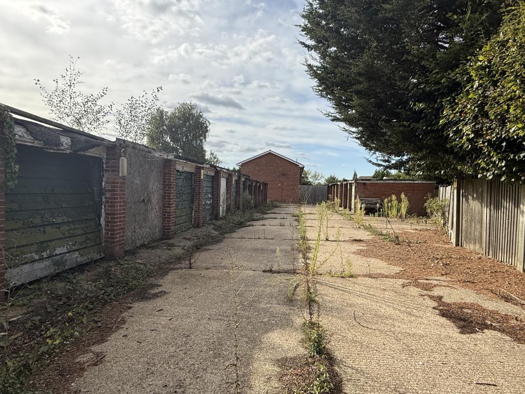 Lot: 4 - COMPOUND OF TWENTY GARAGES AND LAND IN NEED OF REFURBISHMENT TOGETHER WITH AN AREA OF AMENITY LAND - View from far end of site